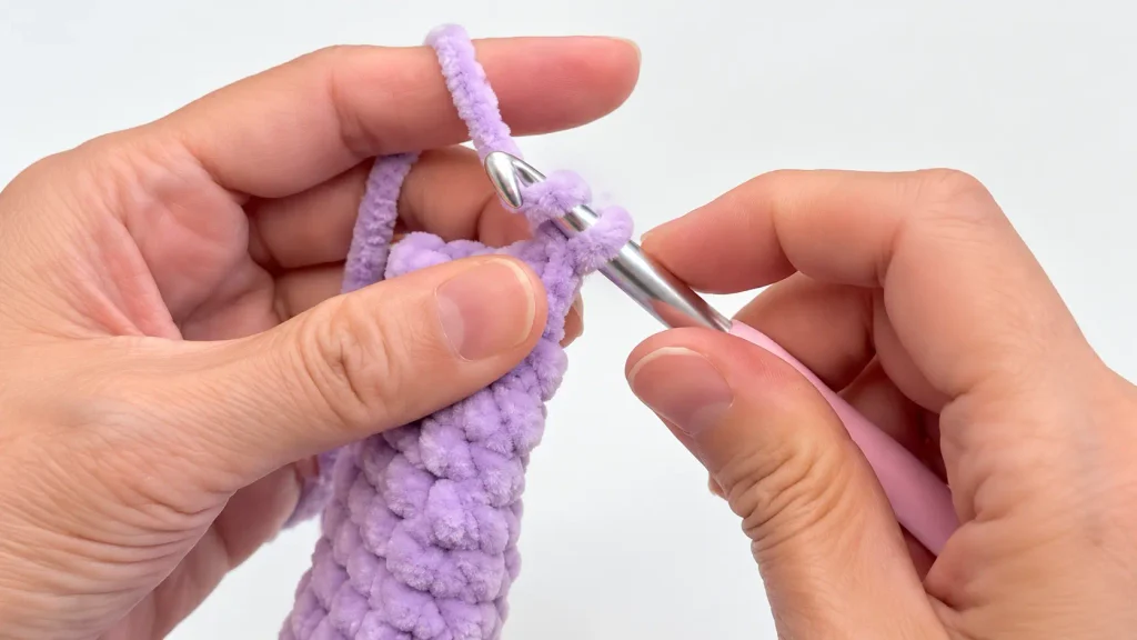 Closing a purple crochet bunny ear with single crochet stitches